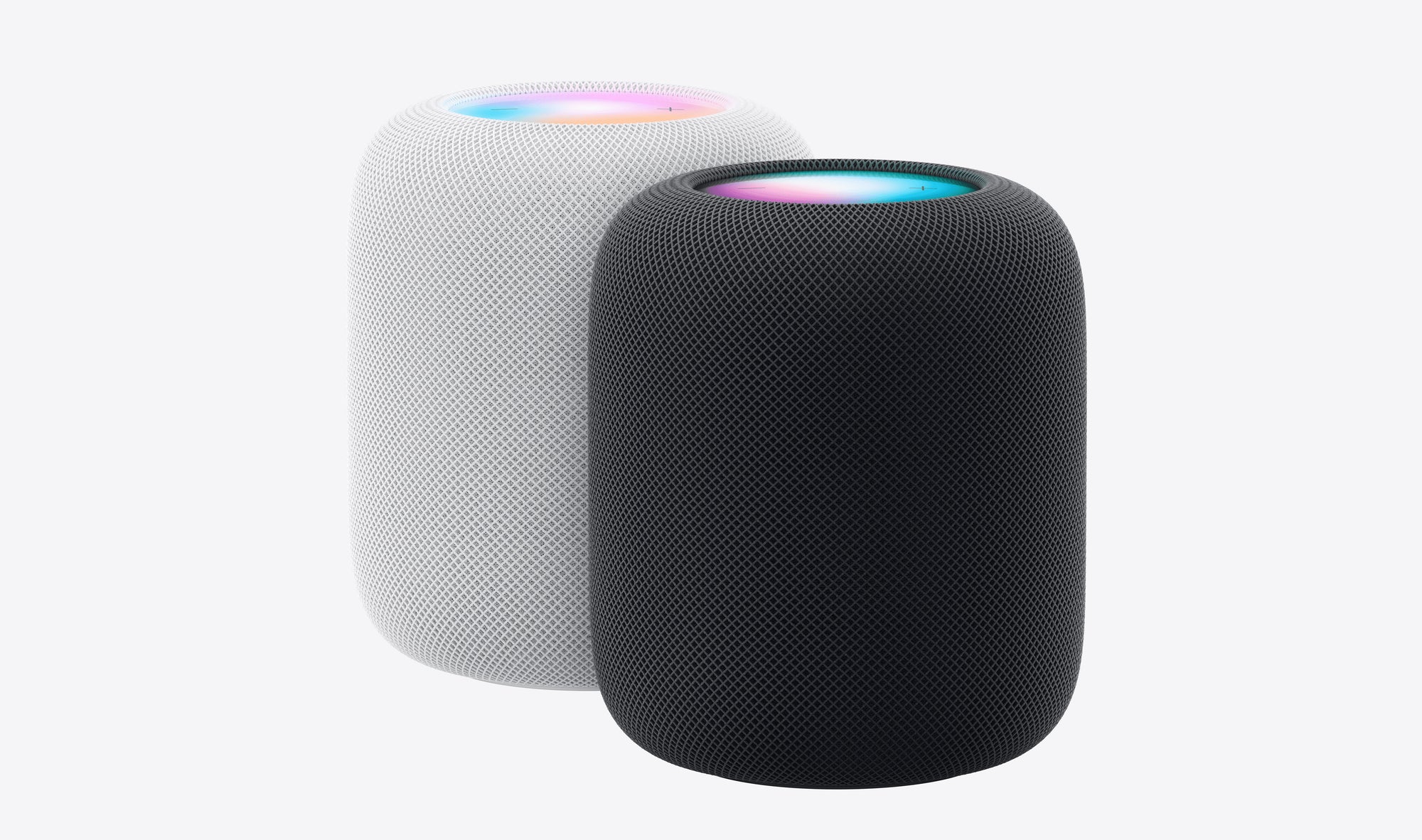 Two Apple HomePod (2nd Gen) smart speakers in white and black stand side by side, each with a mesh exterior and a glowing top—ideal for using Siri voice commands in your smart home.
