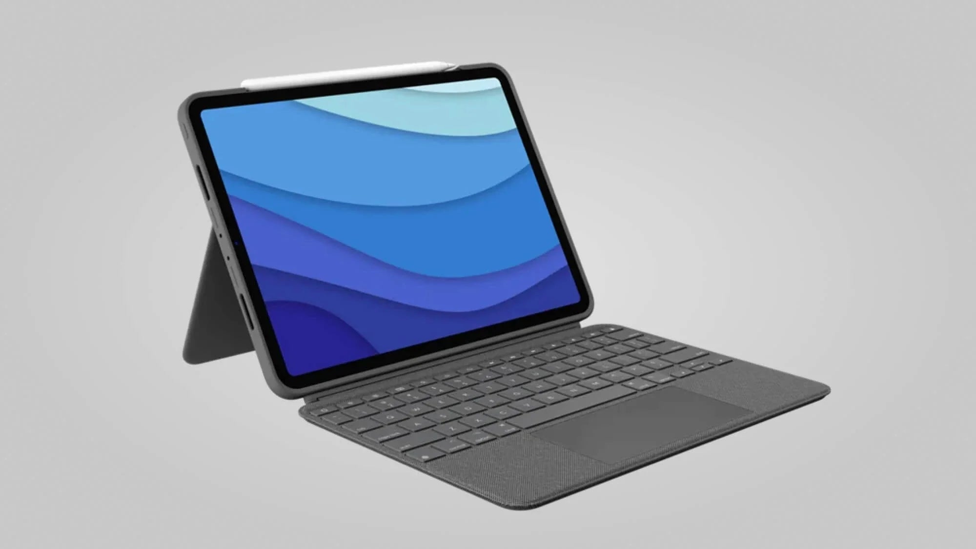 A tablet with a stylus is attached to a keyboard case, displaying a blue abstract background on its screen against a plain light gray backdrop.