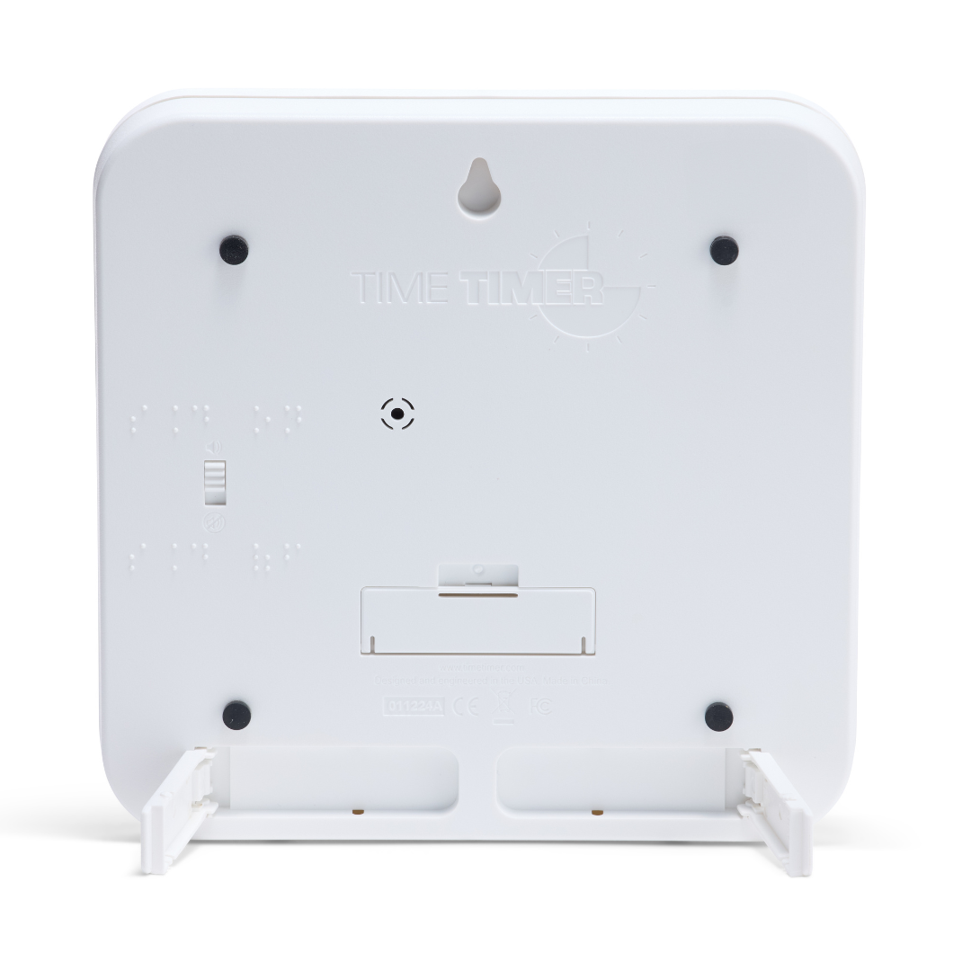 The back of the Time Timer Braille (8 Inch) [Black Disk] by Time Timer shows a battery compartment, wall mount hole, braille markings, and two foldable stands extended at the bottom.