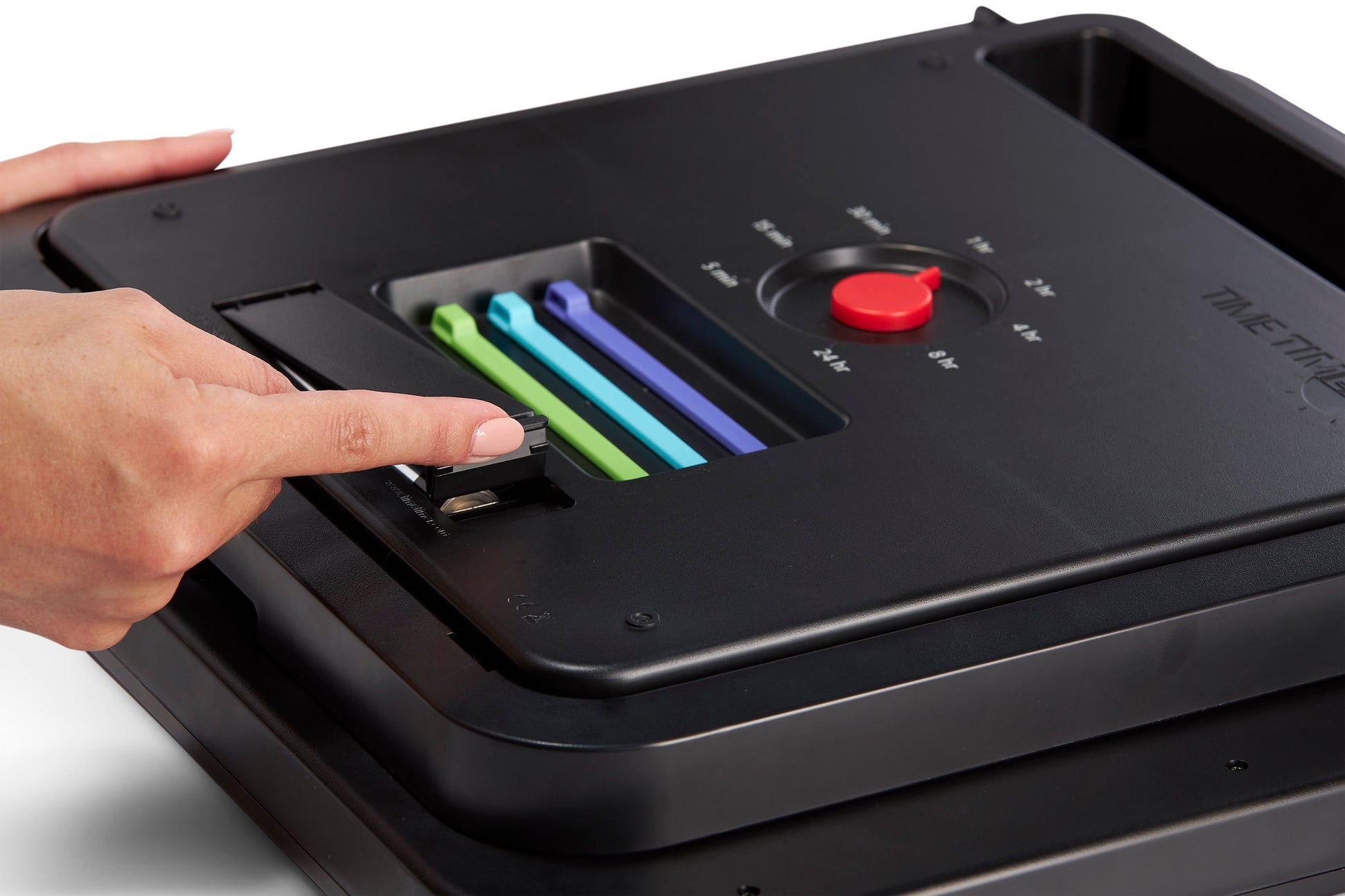 A hand adjusts a black dial on a rectangular Time Timer device with colored bars and numbered settings, using the Time Timer MAX Extra Set Markers (3 Colours) by Time Timer—ideal for timed activities or NDIS session tracking.