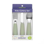 The KiddiKutter Kids Cutlery Set [Sage] by KiddiKutter includes a fork, serrated knife, and spoon with light green silicone handles in purple and white packaging featuring colorful accents and the phrase “Cuts Food, Not Fingers.”.
