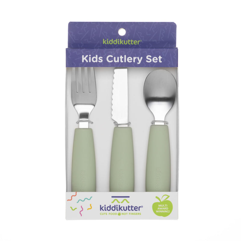 The KiddiKutter Kids Cutlery Set [Sage] by KiddiKutter includes a fork, serrated knife, and spoon with light green silicone handles in purple and white packaging featuring colorful accents and the phrase “Cuts Food, Not Fingers.”.