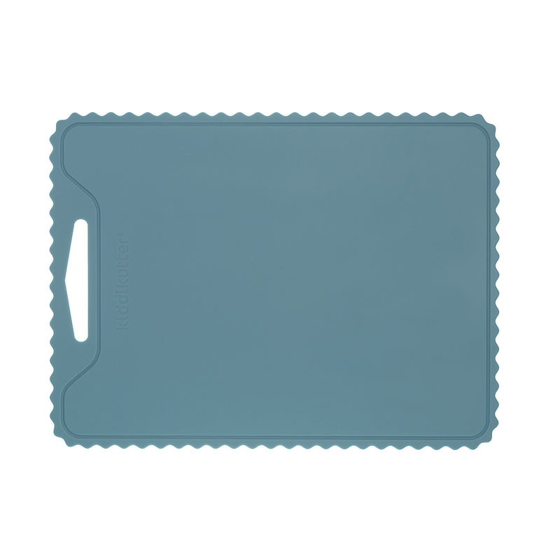 The KiddiKutter Silicone Cutting Board (Wavy) [Sky Blue] by KiddiKutter is a rectangular, non-slip silicone board with a wavy edge and left handle slot, shown on a white background.