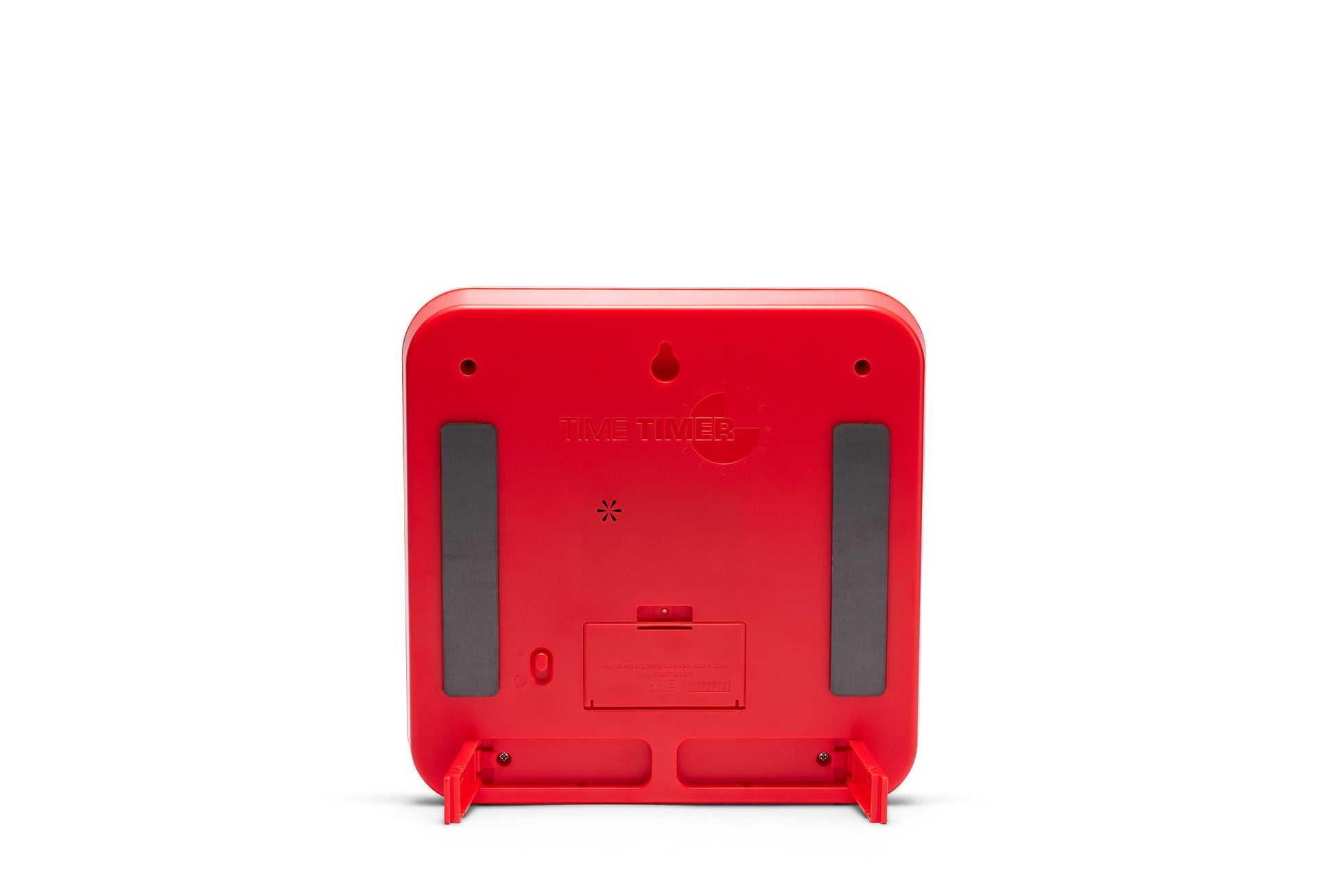 The back view of the Time Timer Original (8 inch) Learning Center Classroom Set (Primary Colour Collection) by Time Timer shows a red, square timer with rounded edges, rubber grips, battery compartment, and two fold-out stands on white.
