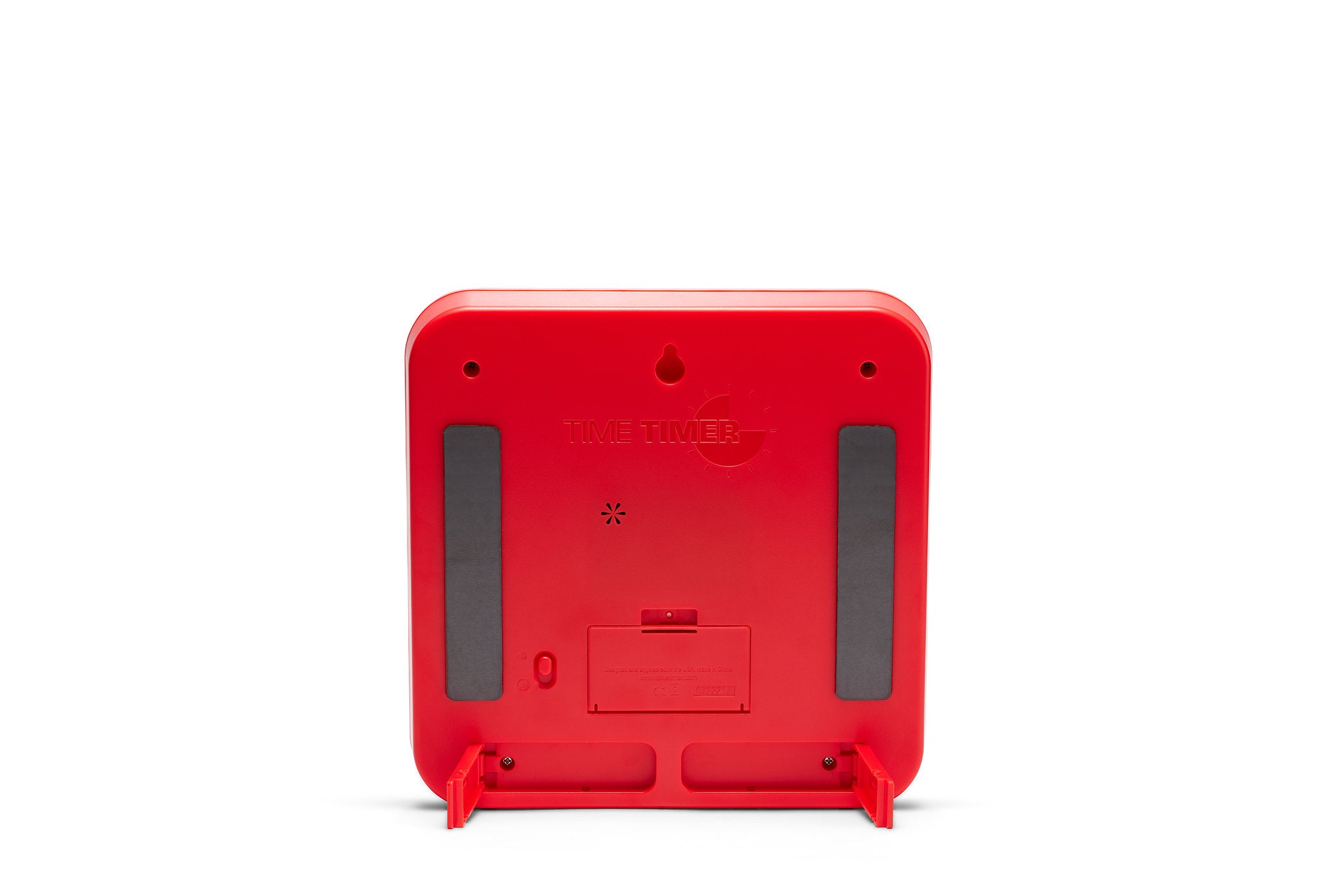 The back view of the Time Timer Original (8 inch) Learning Center Classroom Set (Primary Colour Collection) by Time Timer shows a red, square timer with rounded edges, rubber grips, battery compartment, and two fold-out stands on white.