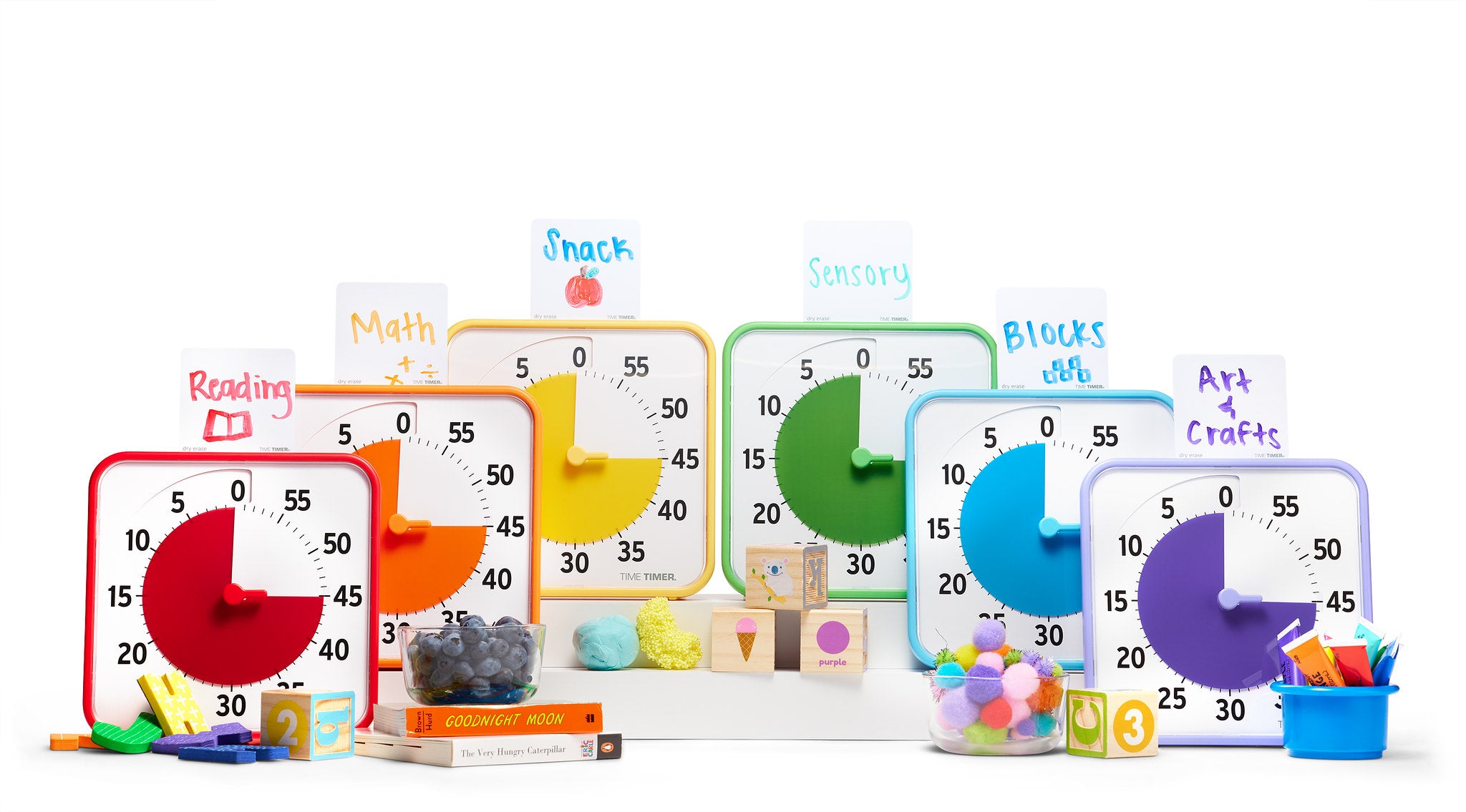 Five Time Timer Original (8 inch) units from the Secondary Colour Collection by Time Timer are displayed in a row, each labeled for different tasks, with related books and items in front—ideal for creating an organized classroom learning center.
