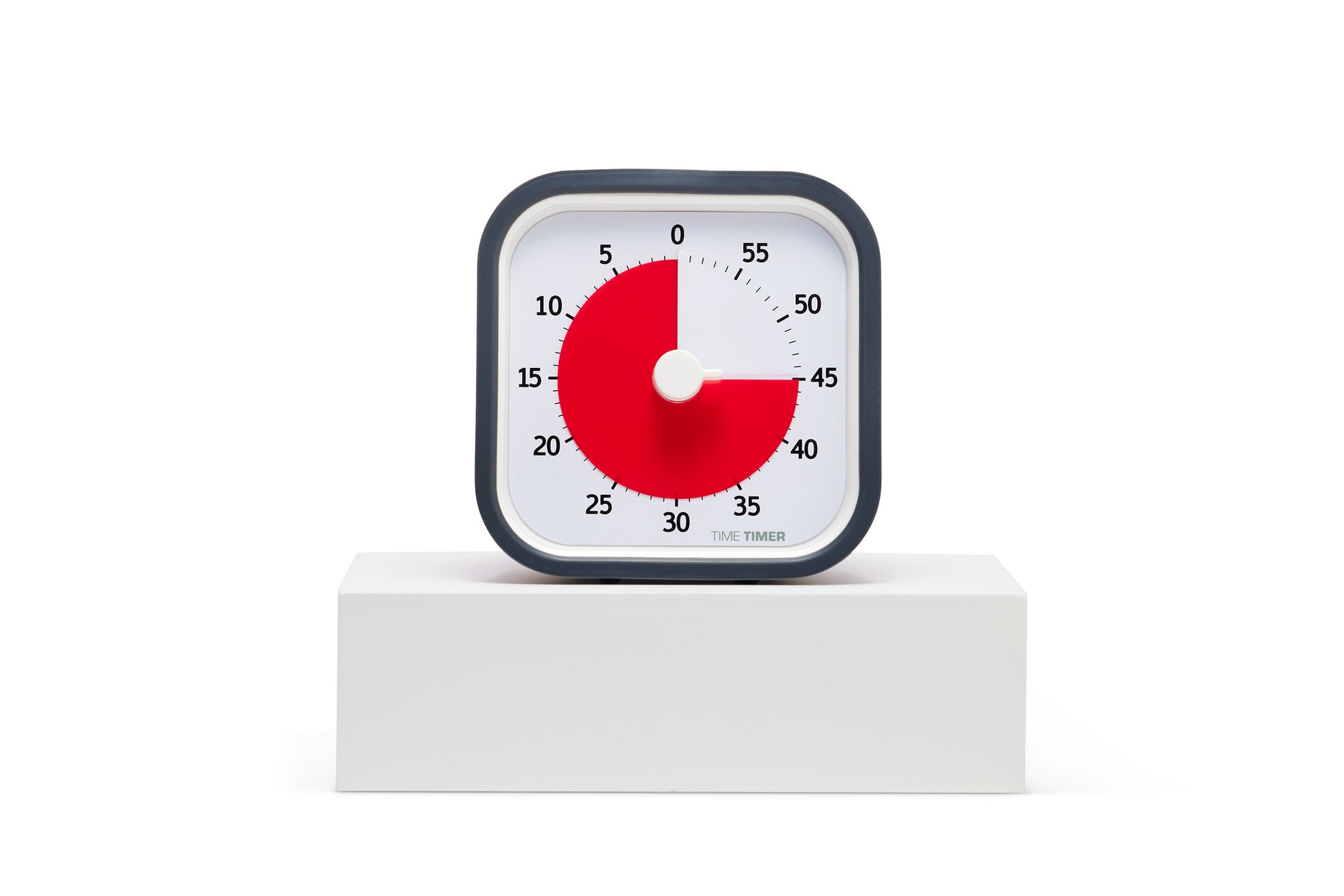 The Time Timer MOD [Charcoal] by Time Timer, a square analog timer with white face, black frame, and red disc marking 25 minutes left, sits on a white platform against a white background—a practical time management tool.