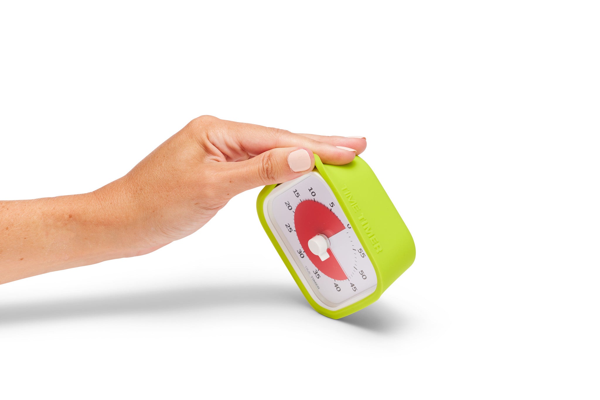 A hand holds a Time Timer MOD [Lime Green] by Time Timer, a small, green, angled 60-minute visual timer with a white dial and red countdown indicator set to about 45 minutes, against a white background.