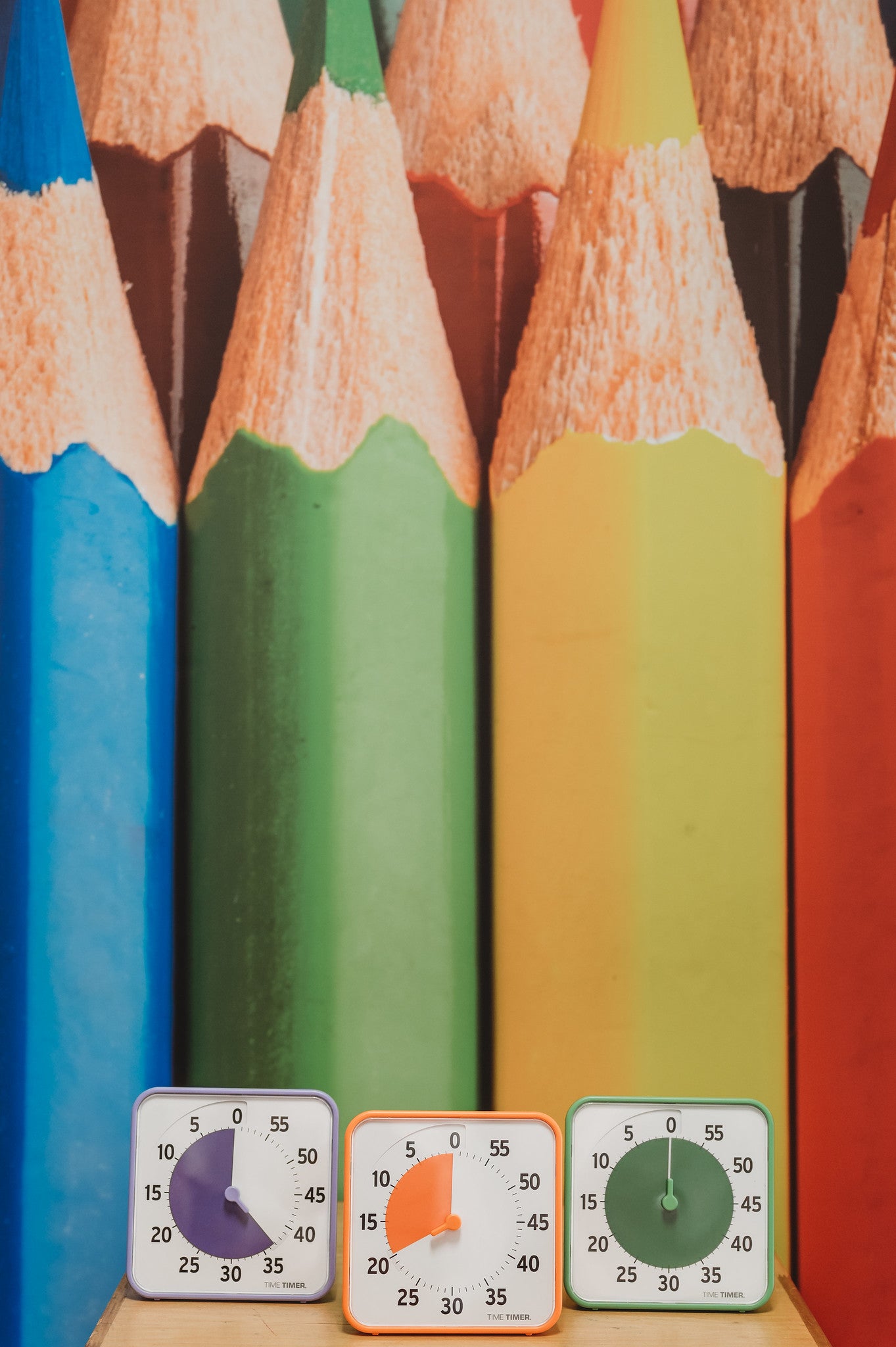 The Time Timer Original (8 inch) Learning Center Classroom Set (Secondary Colour Collection) by Time Timer features three square timers with purple, orange, and green dials, ideal for classroom time management or learning centers.