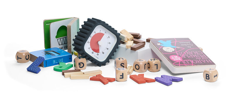 A collection of educational toys, featuring Time Timer MOD + Protect Case – Tread (60 min) by Time Timer, lettered wooden blocks, colored tiles, a green flipbook, a blue card, and a pink children’s book on a white background.