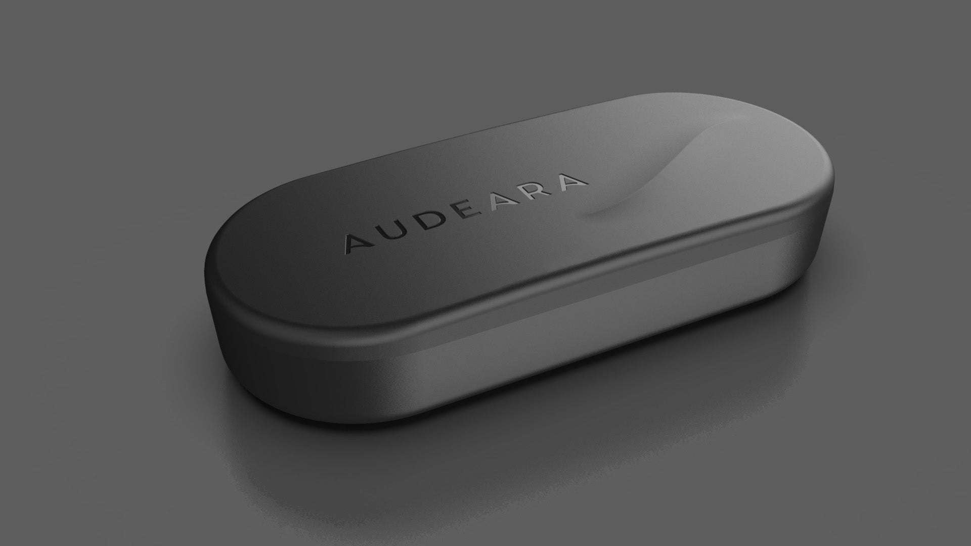 A sleek, black, oval-shaped case with AUDEARA embossed on the lid sits on a gray surface—designed for inclusive listening with advanced Auracast™ technology in the Audeara Broadcaster (Auracast™ Transmitter).