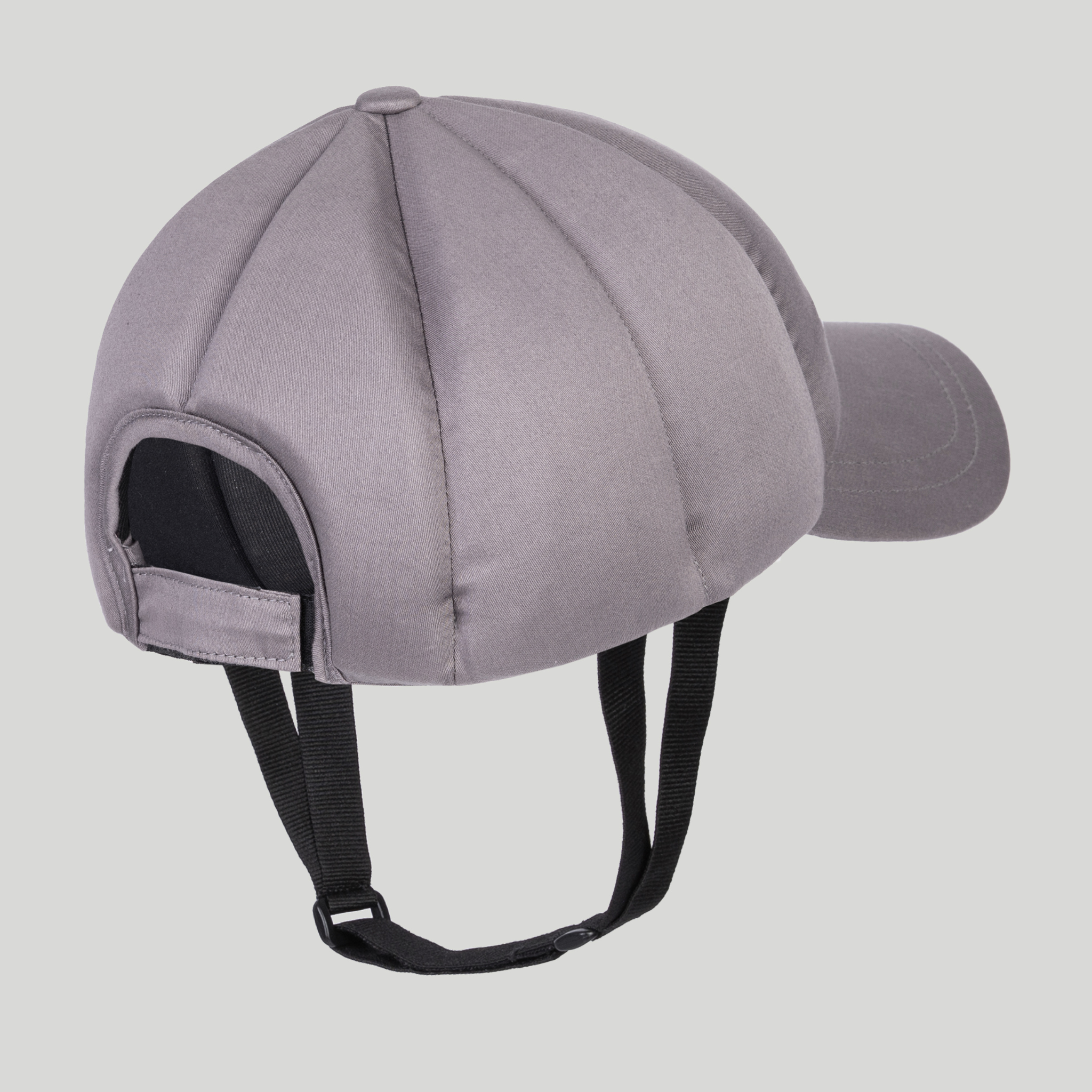The Ribcap Baseball Cap [Platinum] by Ribcap is a gray cap with black adjustable chin straps, a back opening, and soft protective padding—ideal as a discreet medical helmet. Shown on a light gray background.