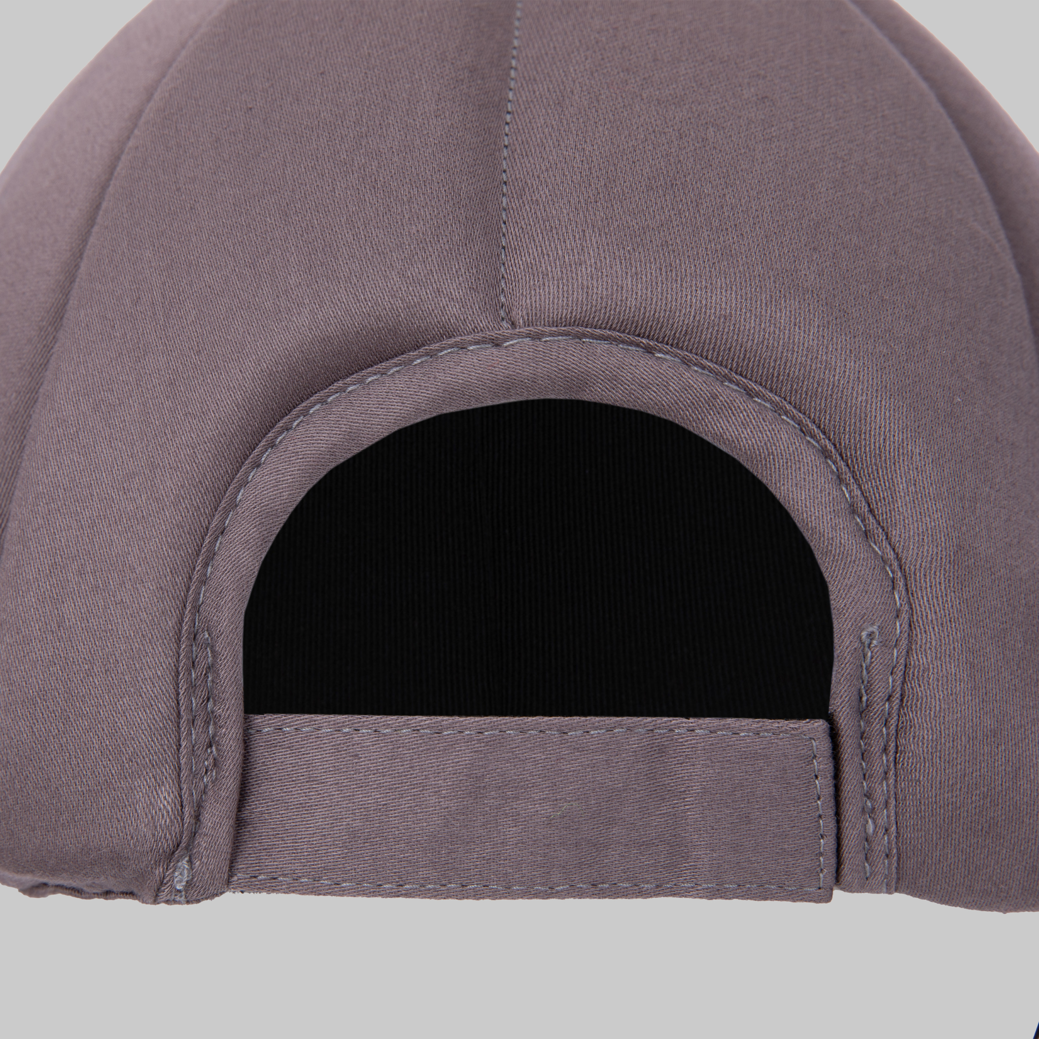 Close-up of the back of a Ribcap Baseball Cap [Platinum] by Ribcap, showing an open adjustable strap, set against a plain light gray background.