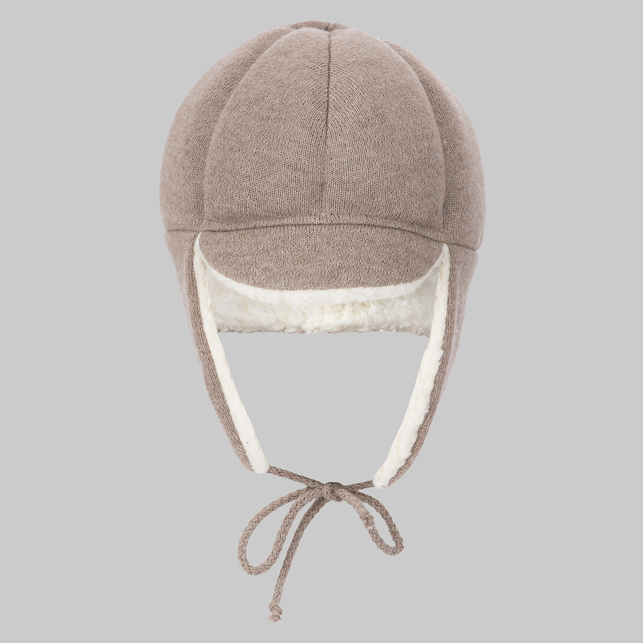 The Ribcap Bieber Kids Beanie [Brown] by Ribcap is a brown knit trapper hat with white fleece lining, ear flaps, and long braided ties for kids' head protection, shown against a light gray background.