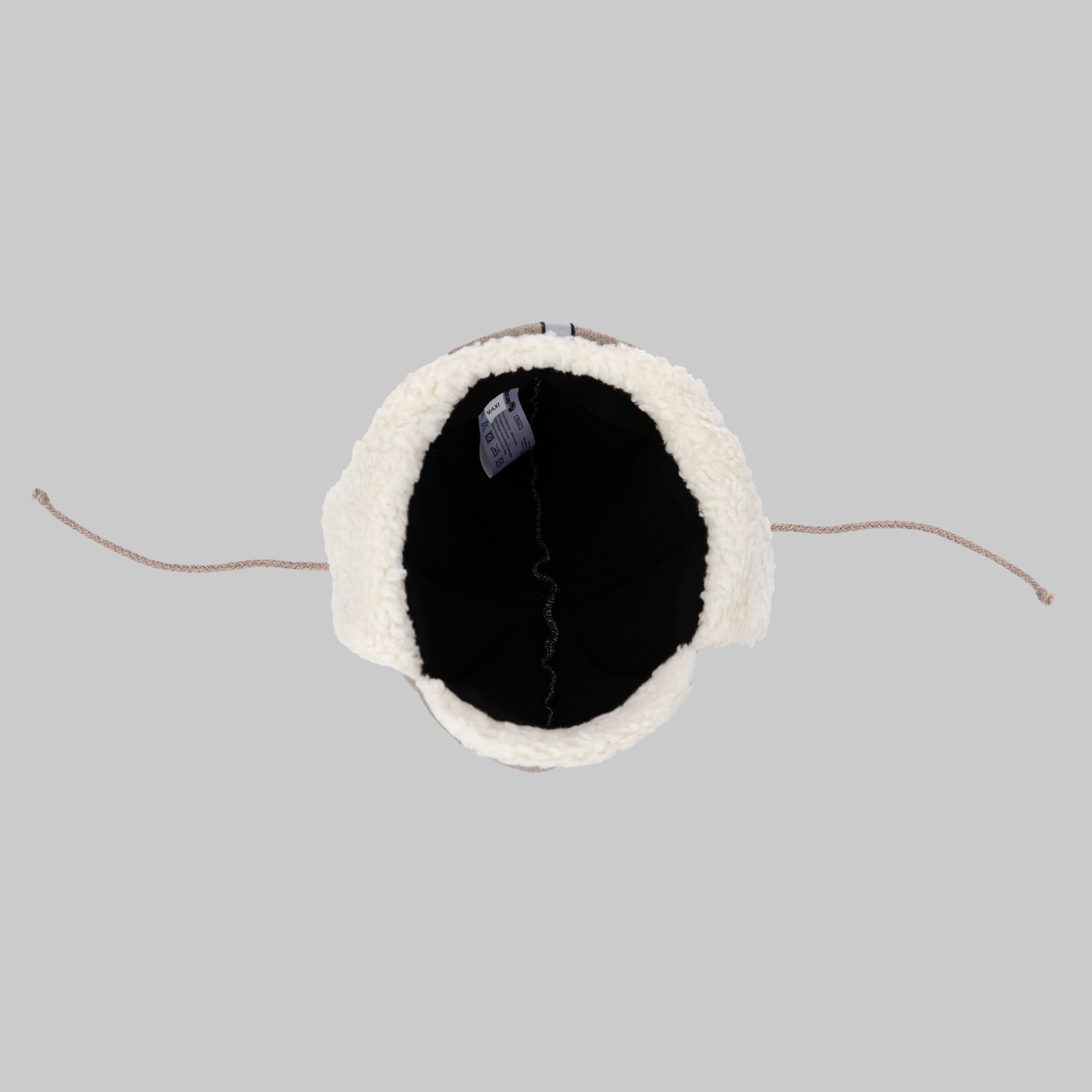 Top view of the Ribcap Bieber Kids Beanie [Brown] by Ribcap, a winter hat with furry white lining, brown drawstrings, and a black interior label, displayed on a plain gray background—cozy and stylish for safe wear.