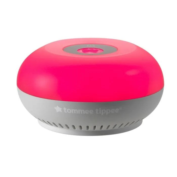 The Tommee Tippee Dreammaker Baby Sleep Aid – Light & Sound Soother is a round, dome-shaped device with a bright pink top and gray base. Featuring CrySensor technology, it soothes babies at night. “Tommee Tippee” appears on the side of the base.