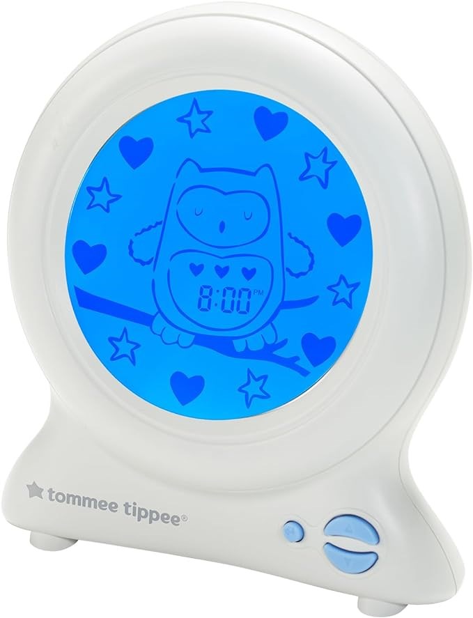 The Tommee Tippee Groclock Sleep Trainer Clock is a round, white children’s clock with a blue screen showing a sleeping owl, stars, hearts, digital time at 8:00 PM, and two buttons on the base—ideal for teaching kids when to wake up.