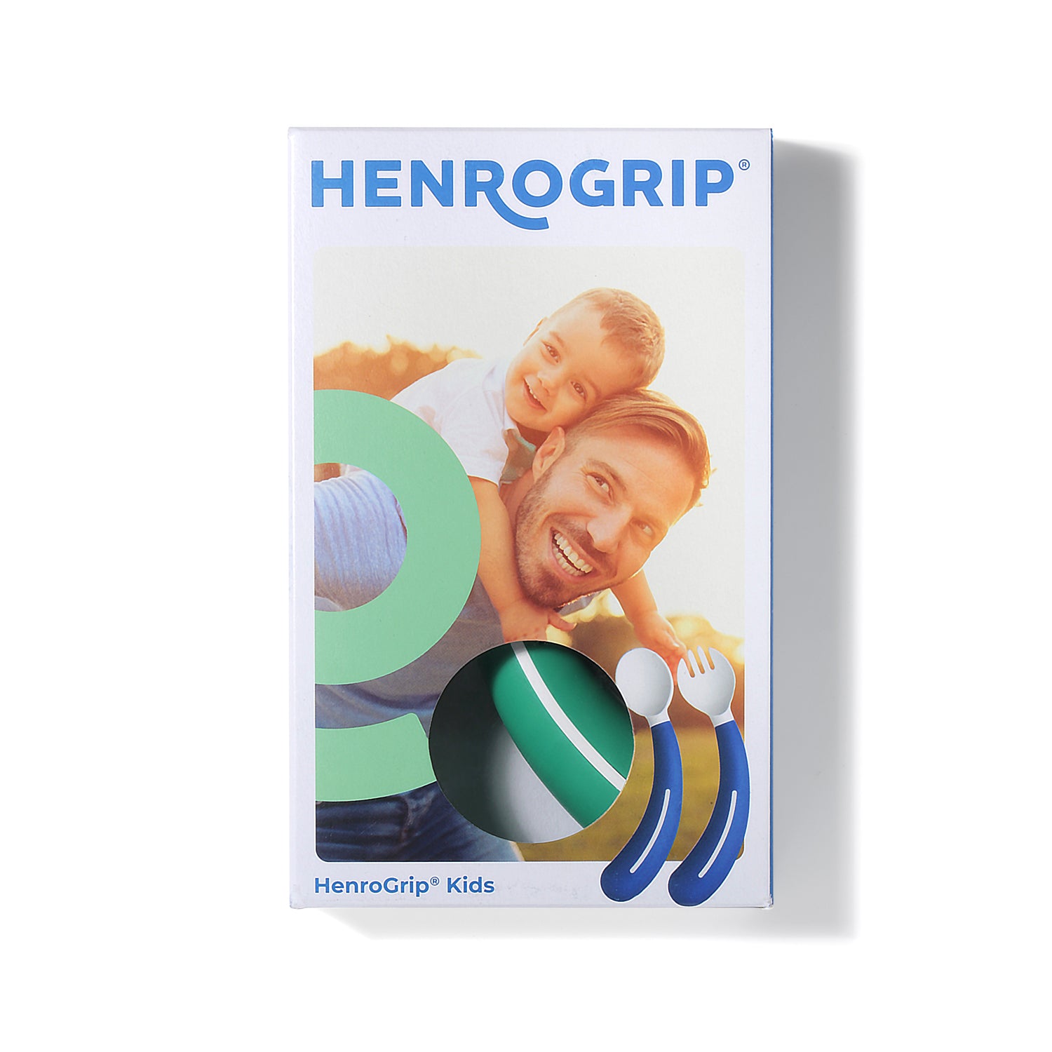A box of Assistive Tech’s HenroGrip Kids Spoon - Green (Left-Handed) shows a smiling man giving a boy a piggyback ride, with green adaptive cutlery visible through a window and fun illustrations of fork and spoon on the packaging.