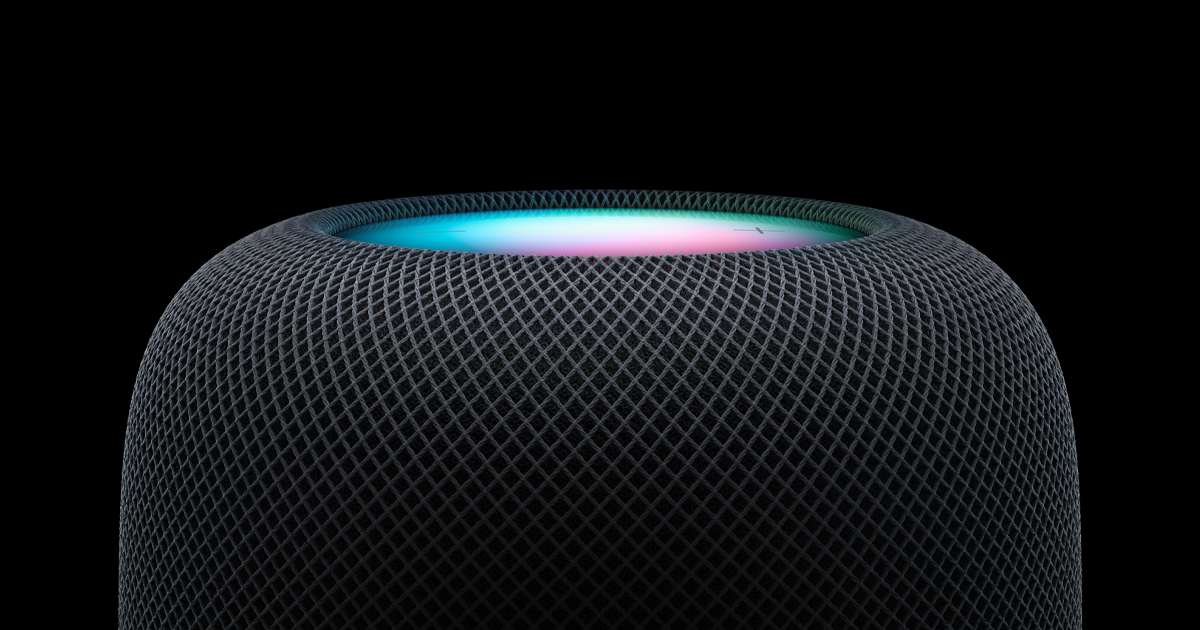 A close-up of the Apple HomePod (2nd Gen) [Midnight] by Apple, showcasing its mesh exterior and glowing multicolored top light against a black background—ideal as a smart home hub with high-fidelity sound.