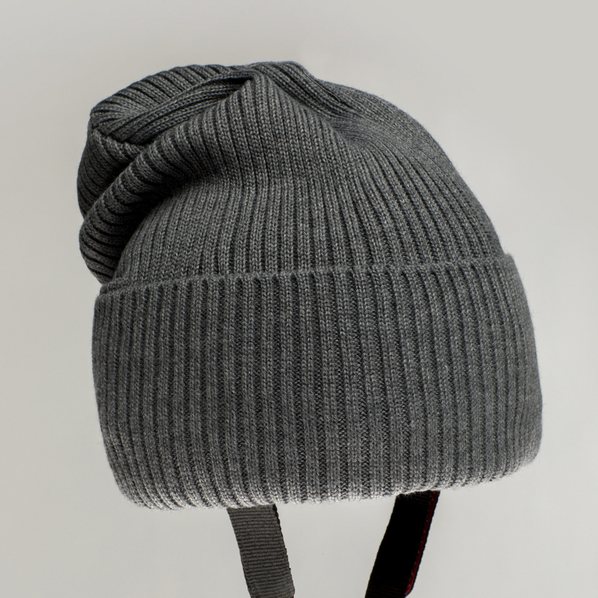 The Ribcap Lenny Beanie Protective Helmet [Grey] is a thick, ribbed adult beanie with a folded brim and two black straps, from the brand Ribcap, shown against a plain light background.