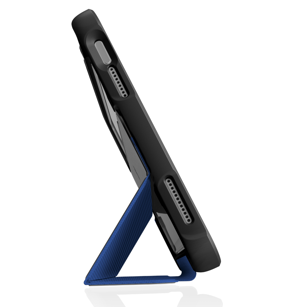 An iPad in the black STM Dux Ultra Case (for iPad A16/10th/11th Gen) is propped sideways by a blue triangular magnetic stand, displaying its bottom edge with speaker grills and charging port against a white background.