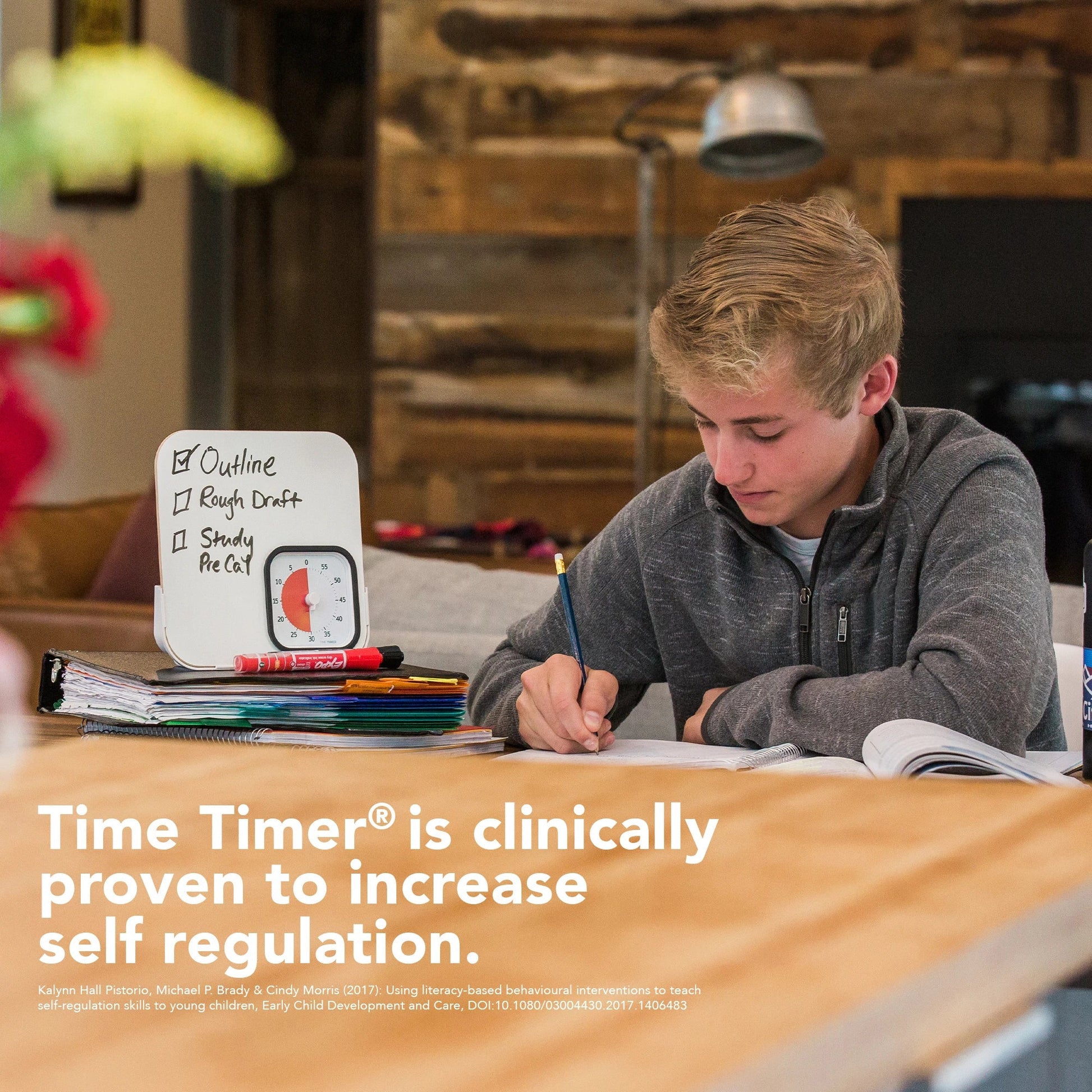 A teenage boy writes in a notebook beside a Time Timer MOD with Whiteboard (60 min) by Time Timer, study materials, and homework steps. The image highlights it as a clinically proven tool for better time management and self-regulation.