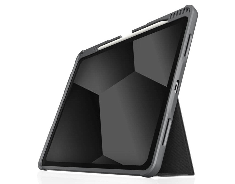 An iPad Pro 11-inch in an STM Dux Plus Case [Black] is propped up, displaying a black geometric pattern. A white stylus rests on top, held by built-in Apple Pencil storage.
