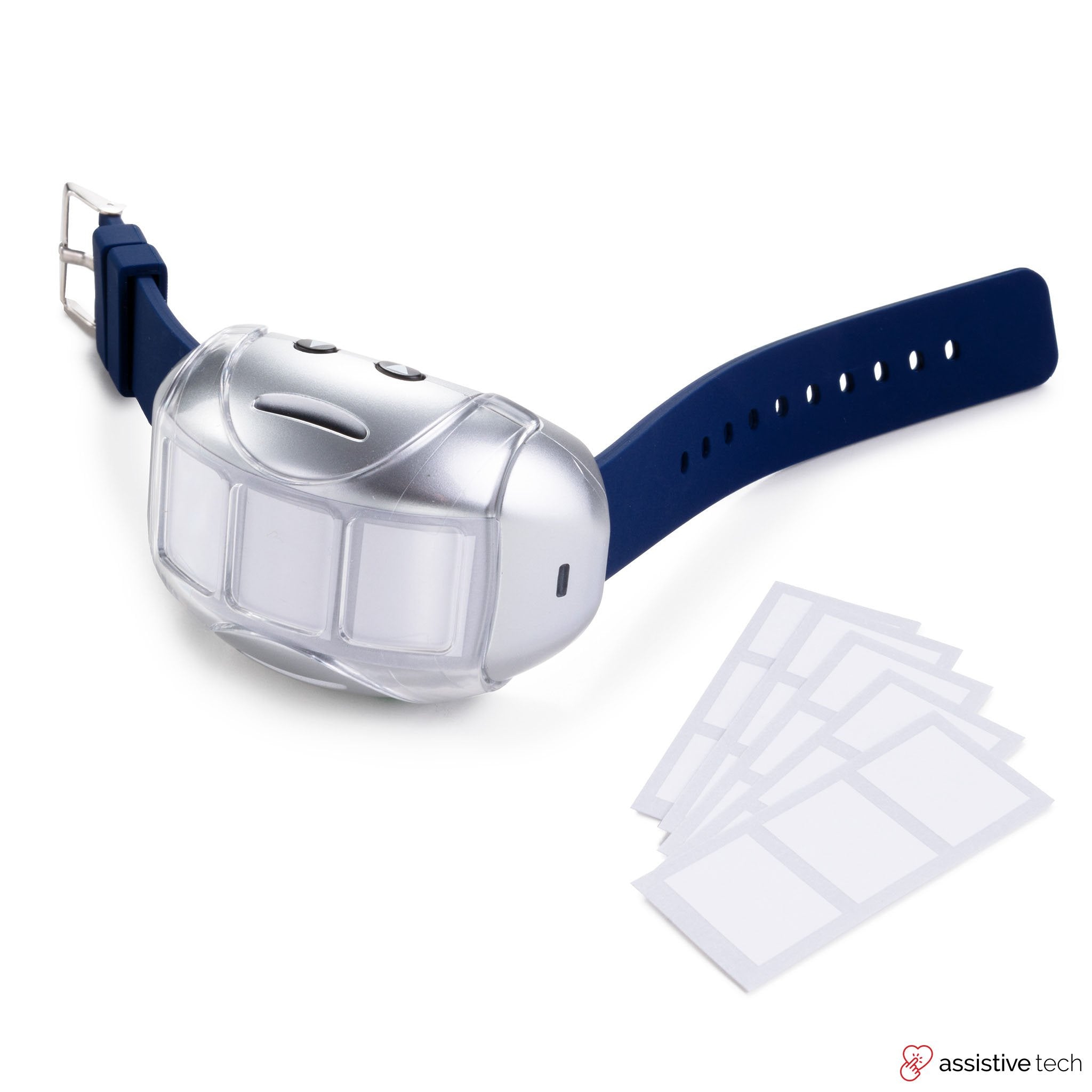 The Attainment GoTalk Go Wearable, a blue AAC device with programmable buttons and a large silver attachment, rests on a white surface alongside five blank adhesive labels.