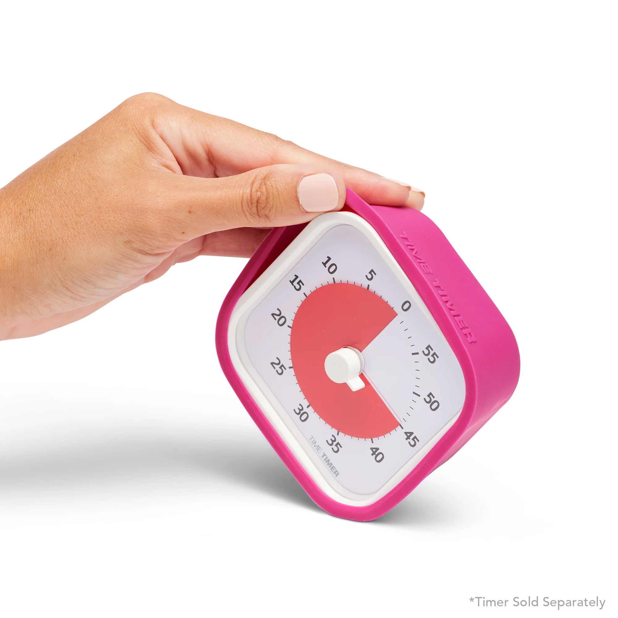 A hand holds a pink Time Timer MOD Cover Silicone Case Accessory by Time Timer, shown on a square timer with white face and red time display. The timer is tilted against a plain white background. Text says: Timer Sold Separately.