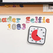 A 12 inch time timer stuck to a whiteboard using its magnetic back.
